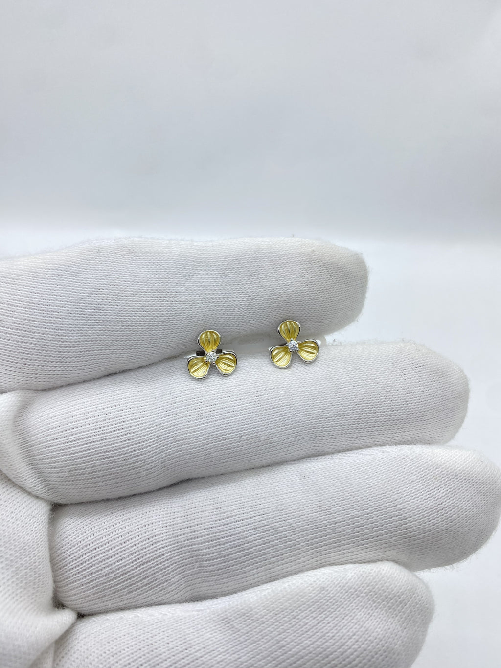 Three-petal flower design in radiant yellow, centered with a luminous white stone earring