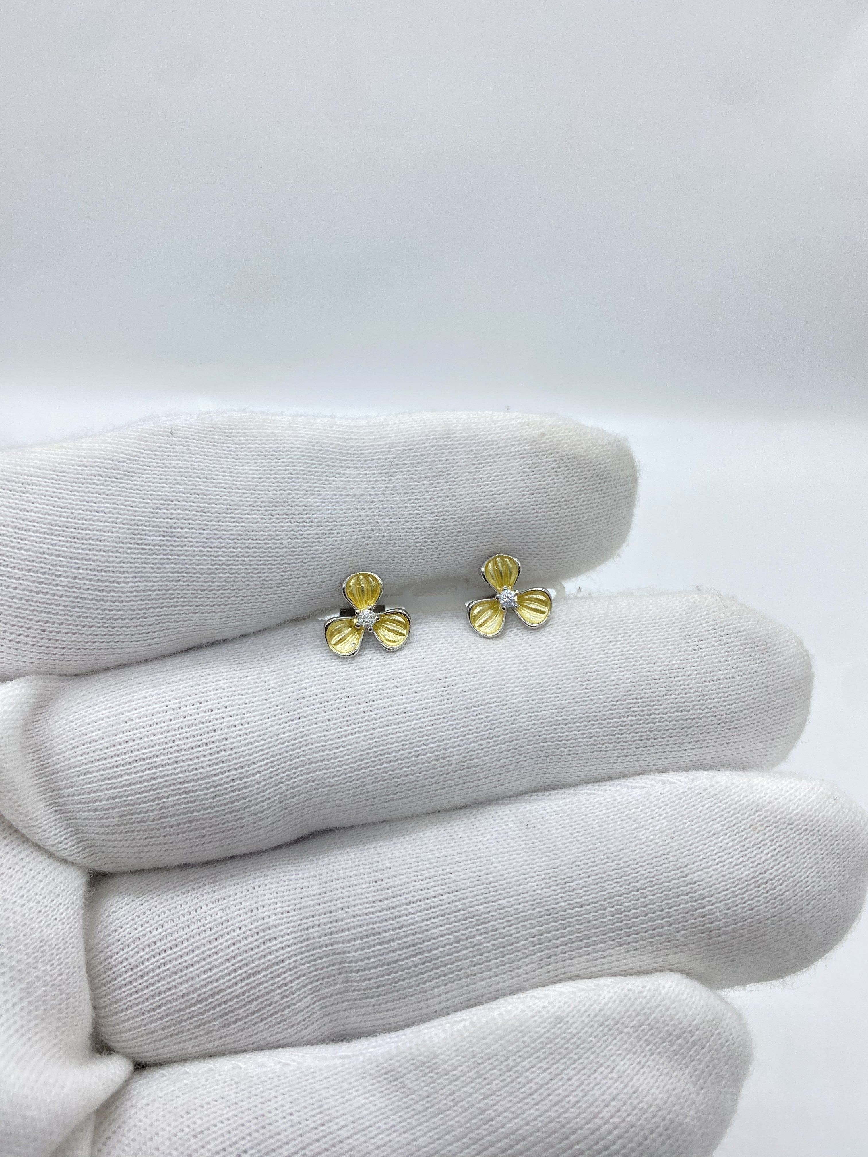 Three-petal flower design in radiant yellow, centered with a luminous white stone earring
